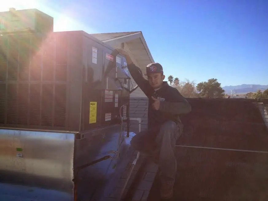 HVAC technician performing AC Tune-Up on a rooftop unit in Applewood